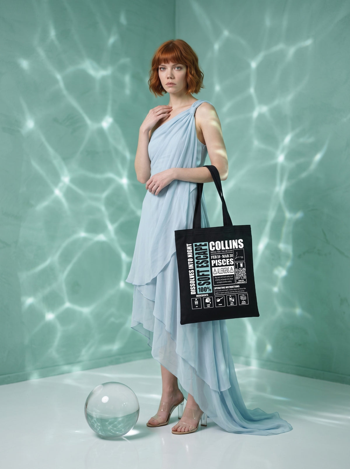 Mr.B Balık Burcu Bez Çanta · Zodiac of Cocktails · Collins · Siyah · Lisa ürünü taşırken (kurgusal karakter, görsel yapay zekâ ile üretildi)